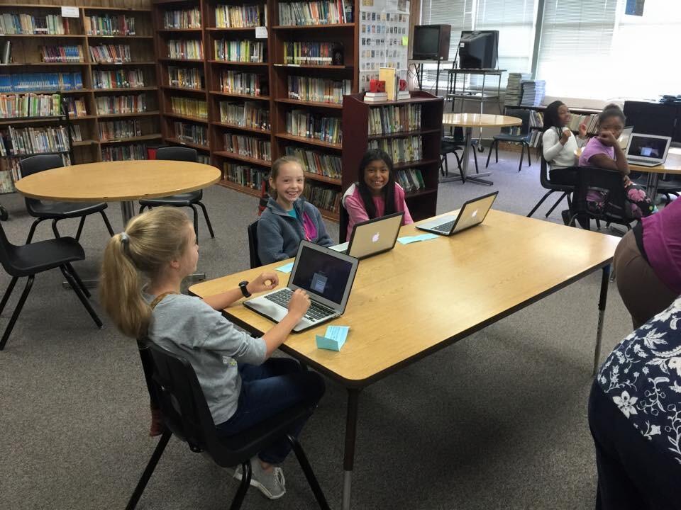 Students using MacBooks in the Library